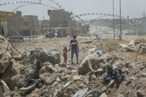 Mosul 2017: Two siblings walk in an area near Mosul’s front line