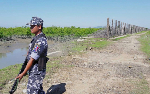 Myanmar border guard police by frontier fence, Maungdaw township