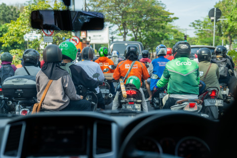 Gig workers in Indonesia. Photo of motorcycle delivery workers in traffic