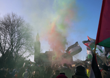 Smoke flares being lit in front of the International Court of Justice